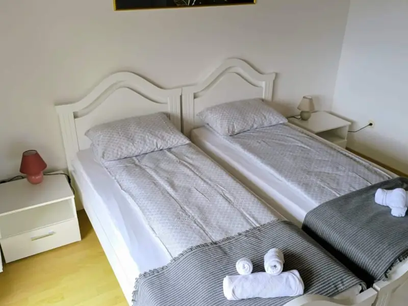 Soba s dva jednostruka kreveta i složenim peškirima